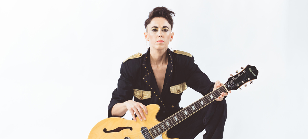 female with yellow guitar in front of white background