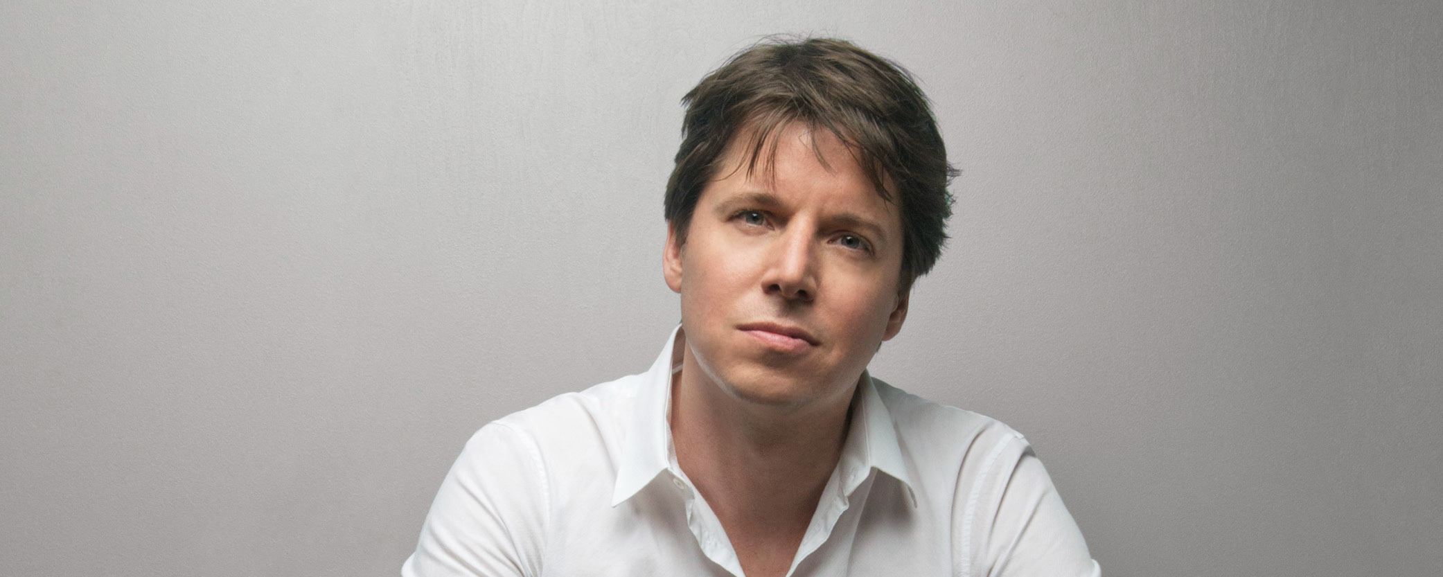 White male with brown hair and white button down shirt.