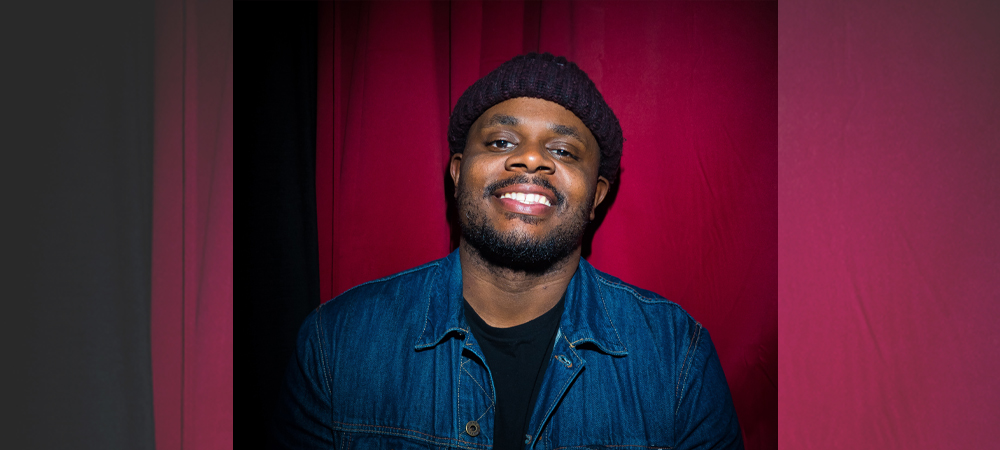 AA Man smiling in front of red curtain